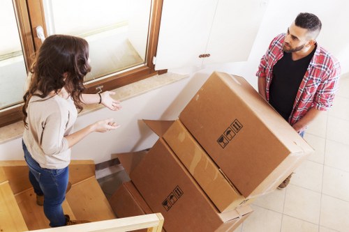 Removalists carrying furniture down stairs in a central London property